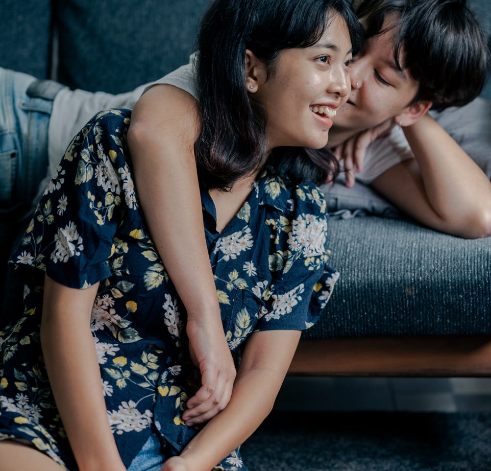 Photo of Couple Sitting on Couch and Floor